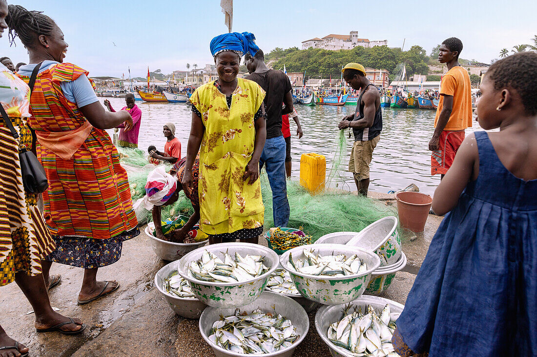 Fischmarkt und Fischerhafen in Elmina mit Blick auf die Festung São Jago da Mina in der Central Region im Westen von Ghana in Westafrika